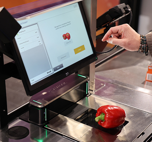 hand selecting a red pepper on self checkout screen